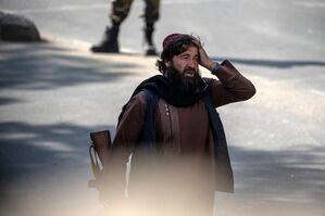 Ein Taliban-Kämpfer steht am Explosionsort und hält sich die Hand an den Kopf., © Ebrahim Noroozi/AP/dpa