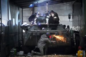 Soldaten der ukrainischen Nationalgarde reparieren einen erbeuteten russischen gepanzerten Mannschaftstransportwagen., © Andrii Marienko/AP/dpa