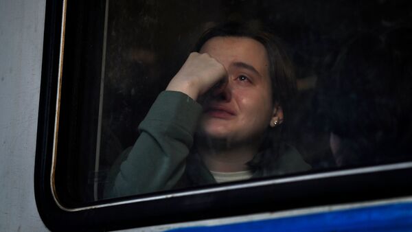 Eine ukrainische Frau sitzt am Hauptbahnhof von Lwiw in einem Zug nach Polen., © Carol Guzy/ZUMA Press Wire/dpa