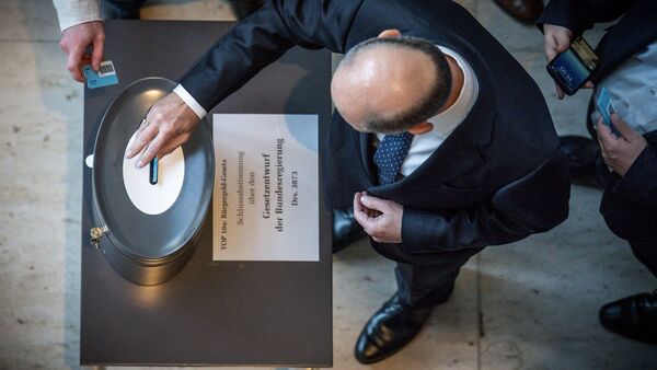 Bundeskanzler Olaf Scholz (SPD), wirft seine Stimmkarte zum Bürgergeld im Bundestag ein., © Michael Kappeler/dpa
