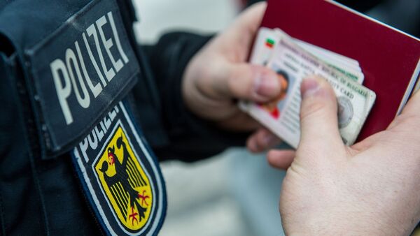 Ein Beamter der Bundespolizei hält bei einer Kontrolle ausländische Ausweise in den Händen., © Marc Müller/dpa