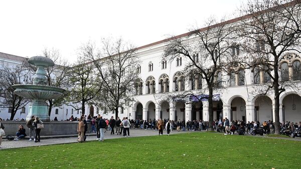 Studenten stehen vor dem Hauptgebäude der LMU., © Felix Hörhager/dpa/Archivbild
