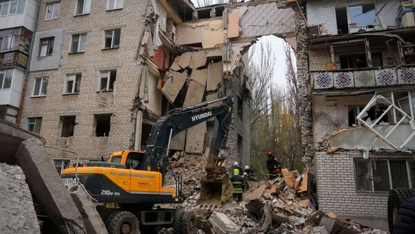 Ukrainische Rettungskräfte am zerstörten Gebäude, das durch russischen Beschuss massiv beschädigt wurde., © Efrem Lukatsky/AP/dpa
