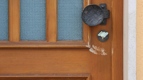 Die Tür zu einem Wohnhaus ist von der Polizei versiegelt., © Karl-Josef Hildenbrand/dpa