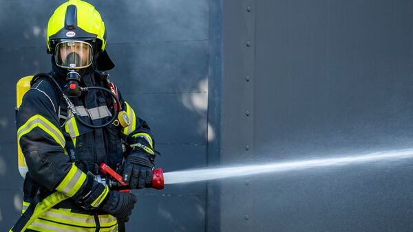 Ein Mitglied der Feuerwehr beim Löscheinsatz., © David Inderlied/dpa/Symbolbild