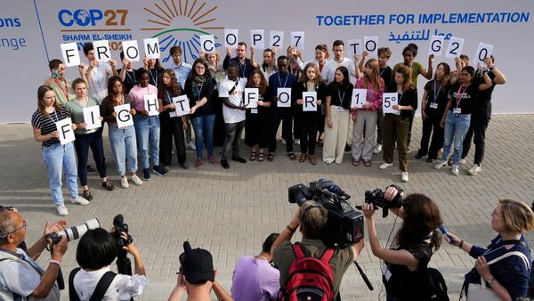 Junge Klimaaktivisten halten in Scharm el Scheich Schilder mit der Aufschrift «From COP27 To G20 Fight For 1.5°»., © Peter Dejong/AP/dpa
