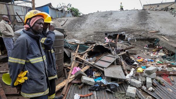 Rettungskräfte stehen vor dem Unglücksort in Nairobi., © Uncredited/AP/dpa