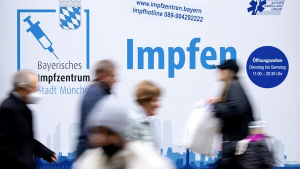 Passanten gehen an einem Impfzentrum in der Münchener Innenstadt vorbei., © Sven Hoppe/dpa