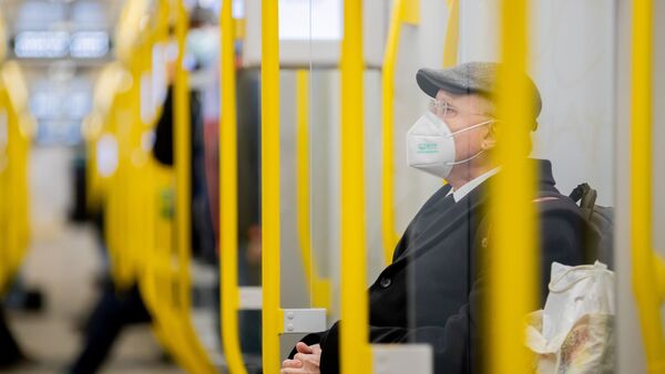 Ein Mann sitzt mit FFP2-Maske in der U-Bahn in Berlin., © Christoph Soeder/dpa