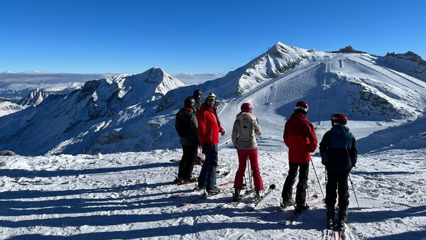 Wintersportler schauen auf ein Skigebiet., © Jan Woitas/dpa/Archivbild